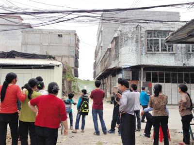 昨日，廣東普寧起火的內(nèi)衣作坊巷口，很多人在圍觀起火居民樓。若不是很多家庭作坊停工，村里很難聚集這么多人。新京報記者 盧美慧 攝